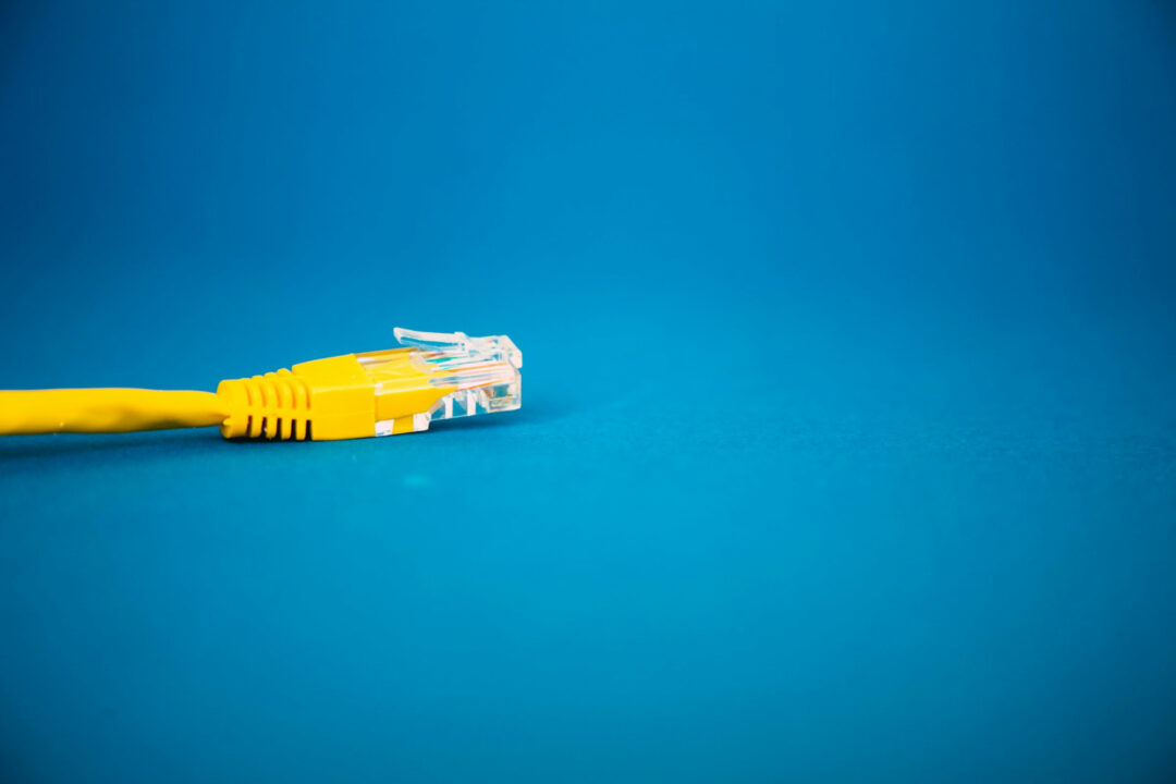 a yellow ethernet cable on a blue background © Markus Spiske, Unsplash License